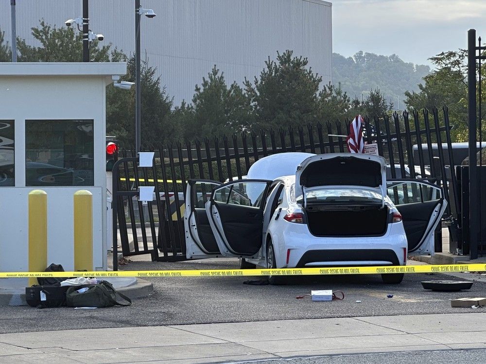 NextImg:Man flees after ramming a car into FBI gate, throws an American flag over the gate