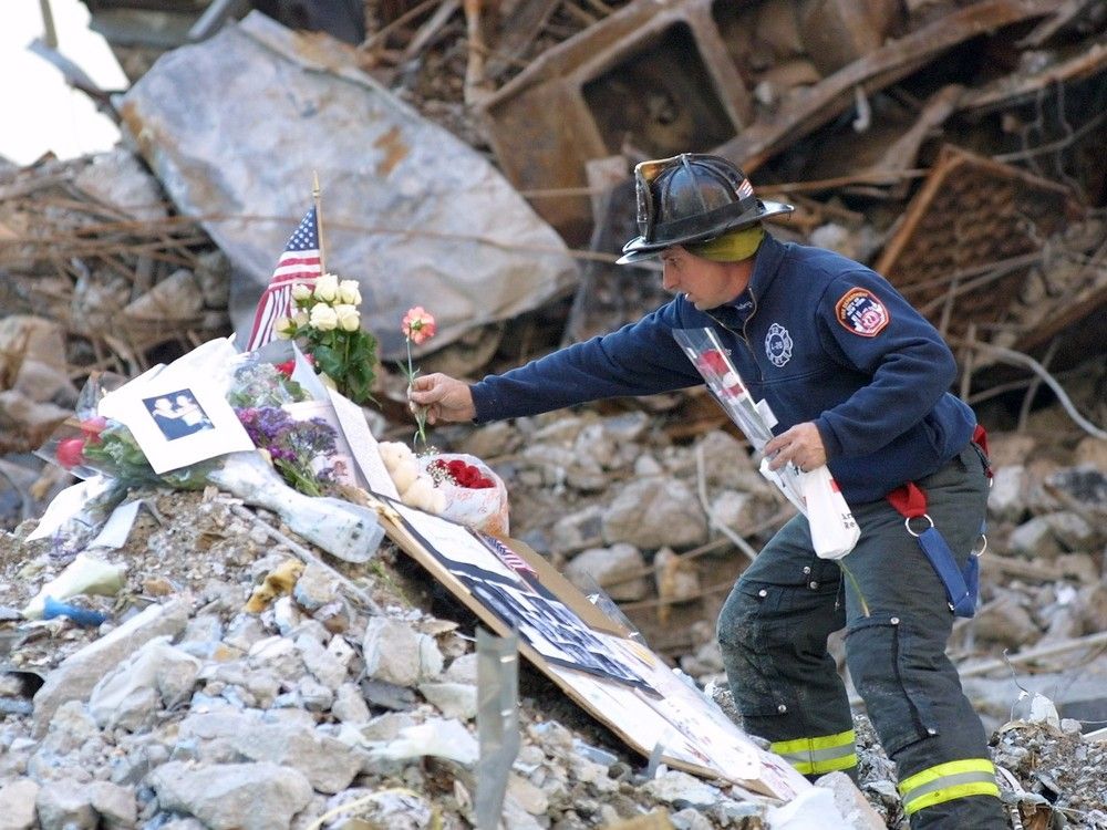  During a service at ground zero in Lower Manhattan on Oct. 28, 2001, firefighters accepted mementos from victims’ families and placed them on the rubble.