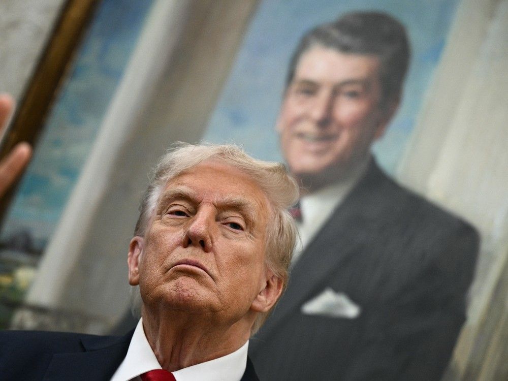 A portrait of former U.S. President Ronald Reagan hangs behind U.S. President Donald Trump in the Oval Office of the White House in Washington, DC, on September 30, 2025.
