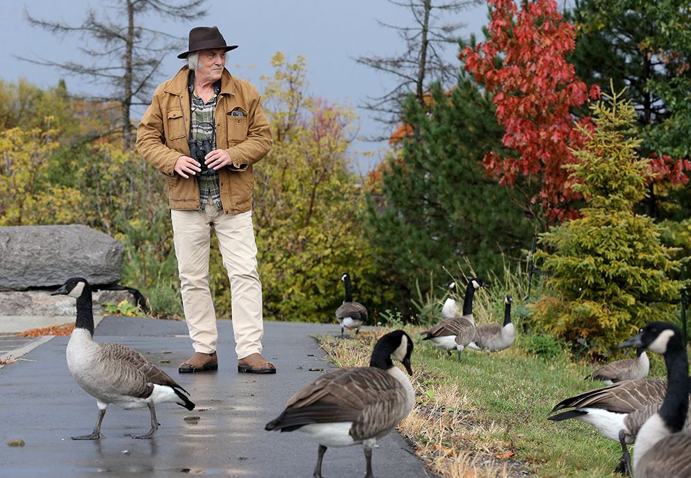 Former Carleton University researcher and professor Mike Runtz outside his old laboratory in a Carleton University parking lot area filled with geese, October 2025.