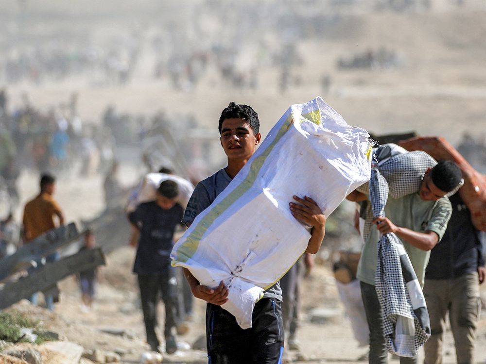 A boy walks with humanitarian aid packages received from the U.S. and Israeli-backed Gaza Humanitarian Foundation. A boy walks with humanitarian aid packages received from the U.S. and Israeli-backed Gaza Humanitarian Foundation.