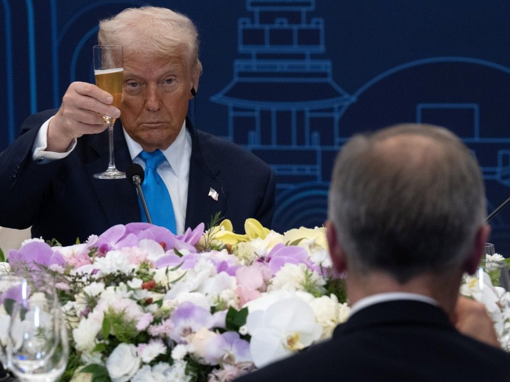 United States President Donald Trump looks towards Canadian Prime Minister Mark Carney as they raise their glasses during a toast at a working dinner in Gyeongju, South Korea on Wednesday,