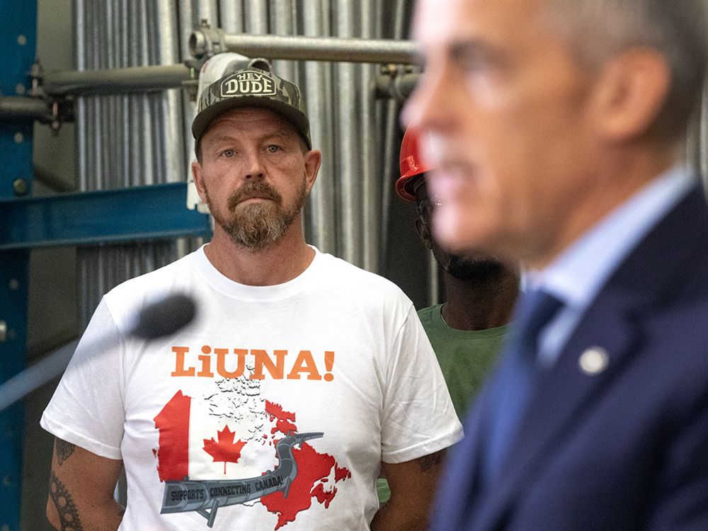 A man wears a pro-pipelines t-shirt as Prime Minister Mark Carney announces five megaprojects under consideration for fast-tracking during a news conference in Edmonton, Sept. 11, 2025. 