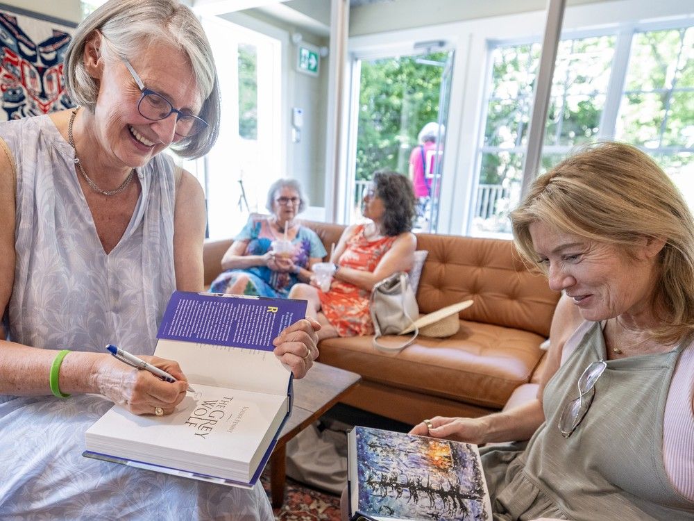  Author Louise Penny autographs a book for Russetta Holcomb, visiting from Solana Beach, Calif., at Café Three Pines in Knowlton, in the Eastern Townships town of Knowlton, southeast of Montreal in July.