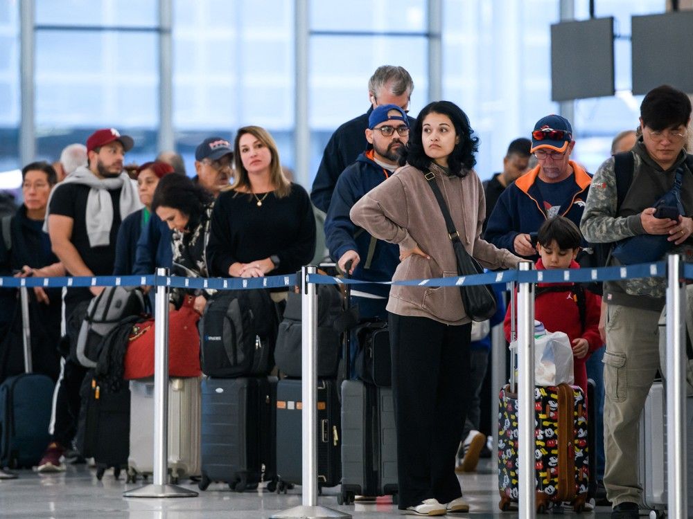  FILE: People wait in a security checkpoint line at George Bush Intercontinental Airport in Houston, Texas, on November 4, 2025.
