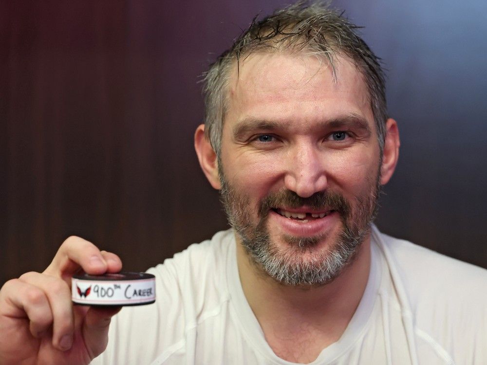  Alex Ovechkin poses the puck he shot to score his 900th career NHL goal Wednesday night in Washington.