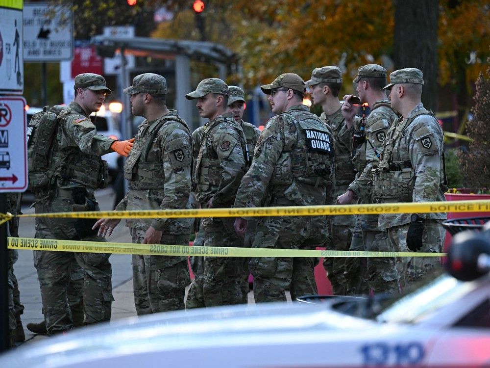  National Guard soldiers stand behind the crime scene tape at a corner in downtown Washington, DC, on November 26, 2025.