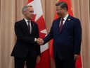 Prime Minister Mark Carney, left, shakes hands with Chinese President Xi Jinping at the start of a meeting in Gyeongju, South Korea, on Oct. 31.