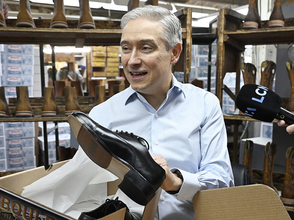 Federal Finance Minister Francois-Philippe Champagne shows the new shoes he will wear for the budget speech, at the Boulet boot factory in St-Tite Que., on Monday, Nov. 3, 2025.