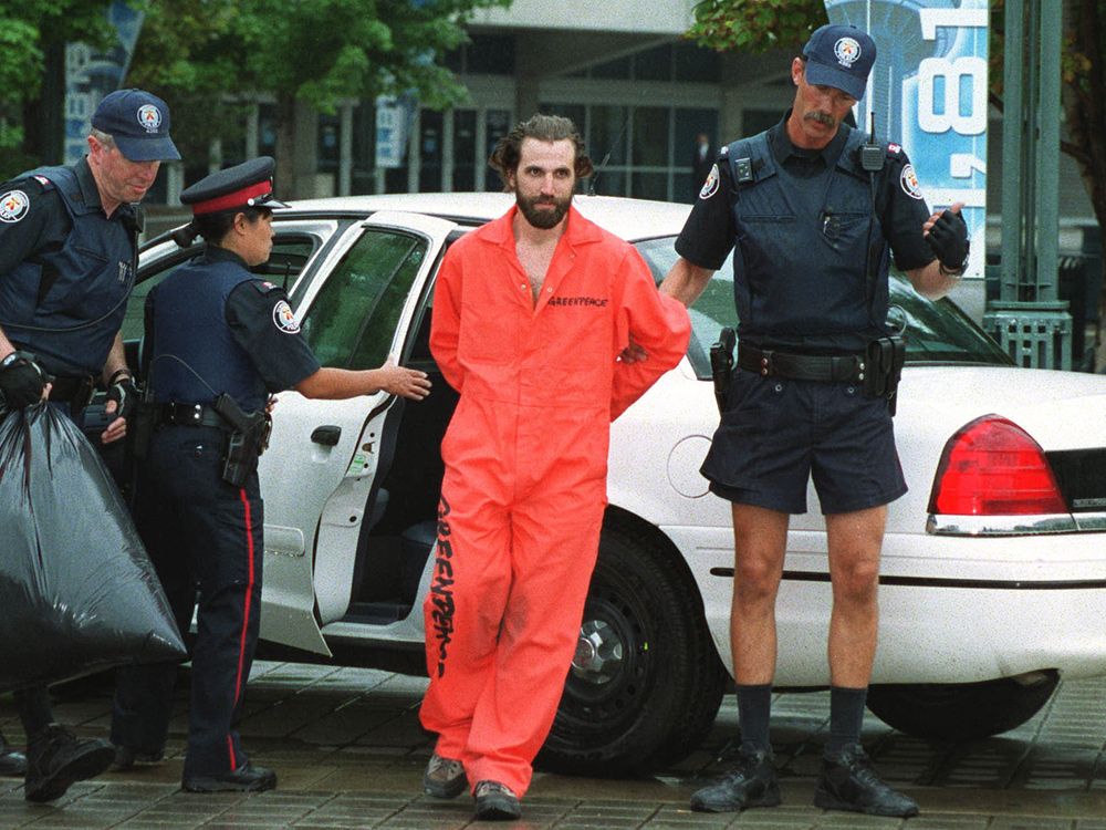  Greenpeace activist Steven Guilbeault is taken into custody by Toronto police after climbing up the outside of the CN Tower in a protest stunt, July 16, 2001.