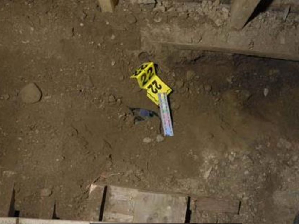 An evidence tag on the dirt floor shows where a metal detector told police to dig. Underneath they found $1.2 million hidden in a tub. An evidence tag on the dirt floor shows where a metal detector told police to dig. Underneath they found $1.2 million hidden in a tub.