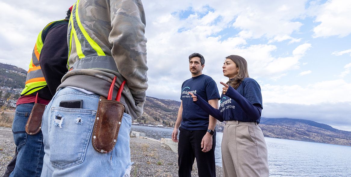 Navid Bayat and Lorena Ordonez from the Migrant Workers Centre in Kelowna, B.C., talk with migrant workers on Nov. 23, 2025.