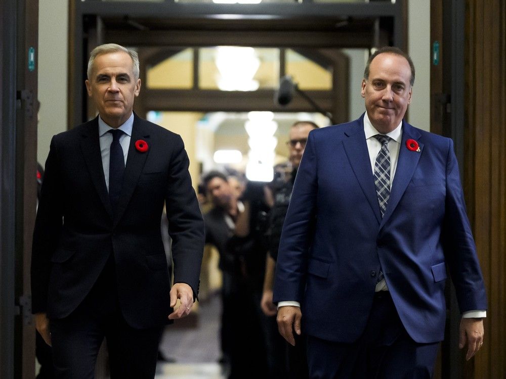 Prime Minister Mark Carney with MP Chris d'Entremont, who crossed the floor from Conservative caucus to join the Liberals on Budget Day, as they walk to a meeting of the Liberal Caucus on Parliament Hill, Nov. 5, 2025.