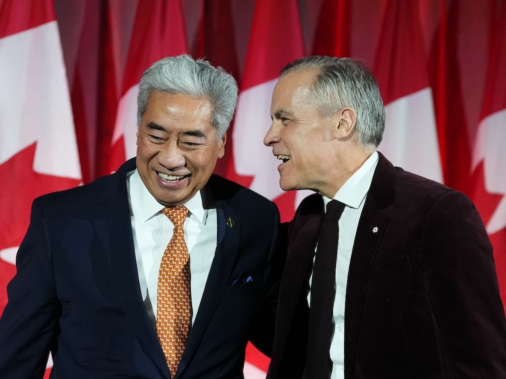 Prime Minister Mark Carney embraces Michael Ma, Member of Parliament for Markham-Unionville, who crossed the floor from the Conservatives to the Liberals hours earlier, at the Liberal caucus holiday party in Ottawa, on Thursday, Dec. 11, 2025. 