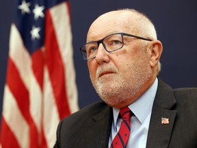 Pete Hoekstra with a U.S. flag in the background.
