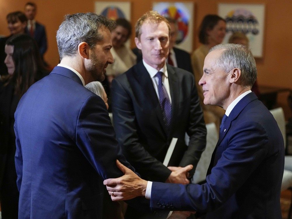  Prime Minister Mark Carney shakes hands with Procurement Minister Joel Lightbound at a cabinet swearing in ceremony at Rideau Hall in Ottawa on Dec. 1, 2025.