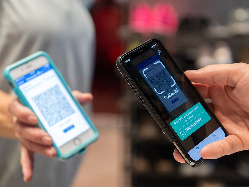  A customer has her COVID-19 QR code scanned by the manager of a fitness club in Montreal as the Quebec government’s COVID-19 vaccine passport comes into effect, Sept. 1, 2021.
