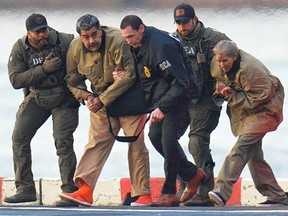 Five people walking along the a dock