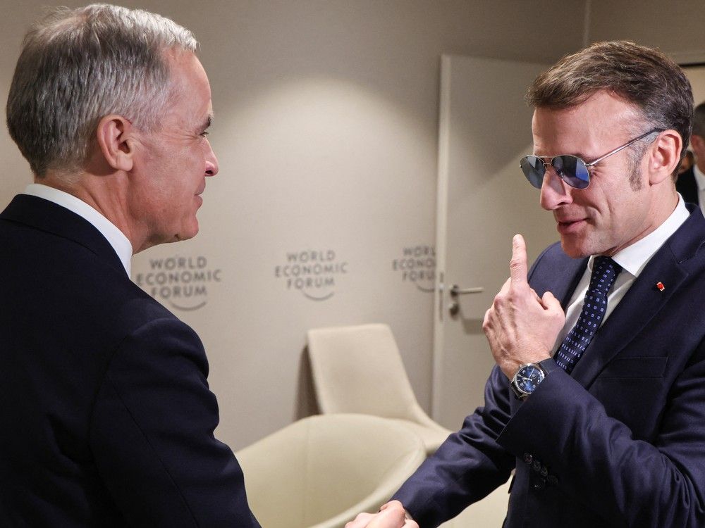 French President Emmanuel Macron, right, greets Canadian Prime Minister Mark Carney prior to a bilateral meeting on the sidelines of the World Economic Forum (WEF) annual meeting in Davos, Switzerland on Tuesday.