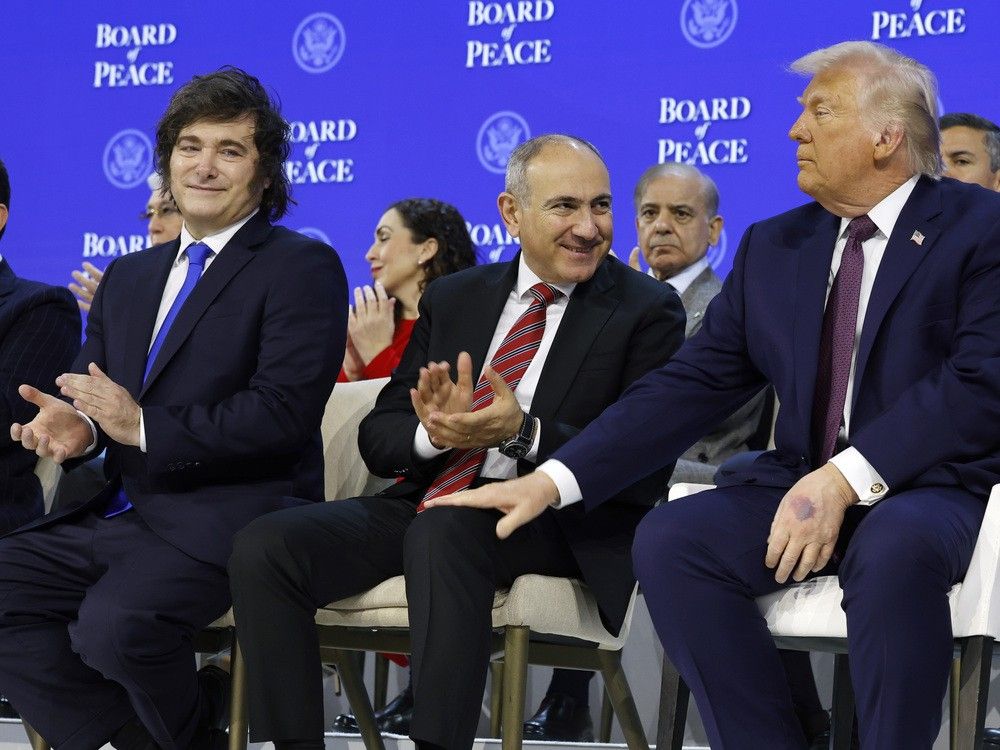  U.S. President Donald Trump, far right, pats Armenia’s Prime Minister Nikol Pashinyan on the knee as Agentine President Javier Milei, left, looks prior to Board of Peace signing event in Davos, Switzerland on Thursday.