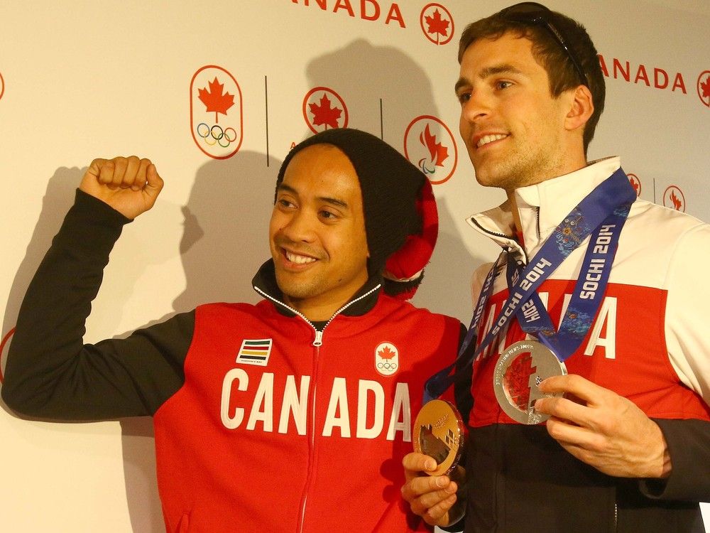  Canada’s Olympic speedskaters Gilmore Junio and Denny Morrison (right) pose for photos as they arrived home at the Calgary International Airport in Calgary, Alta. on Tuesday February 25, 2014.