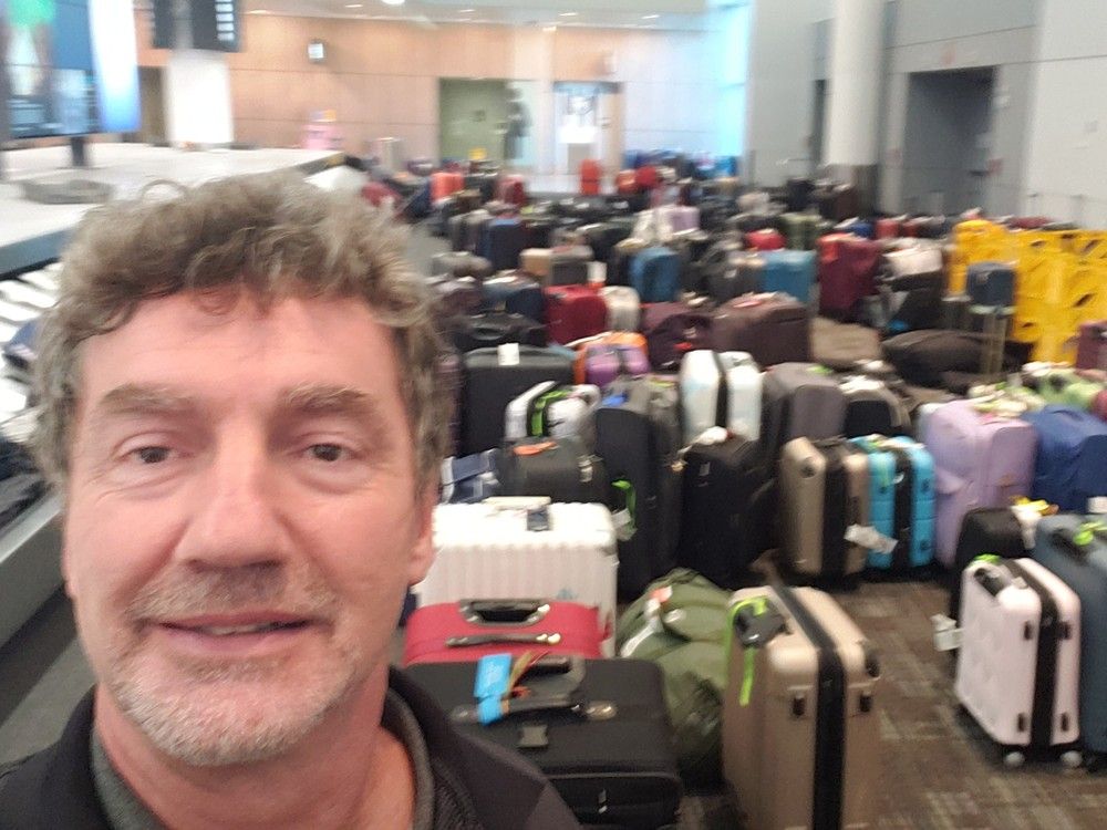  Rejean Landry at Pearson Airport in front of what he called a “mountain of unclaimed suitcases” during the fraught summer of air travel in 2022. (Photo credit: Rejean Landry)