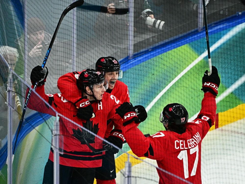 Canada's Nathan Mackinnon (left) celebrates after scoring the game-winning goal against Finland during the men's play-off semifinal at the Milano Cortina 2026 Winter Olympic Games.