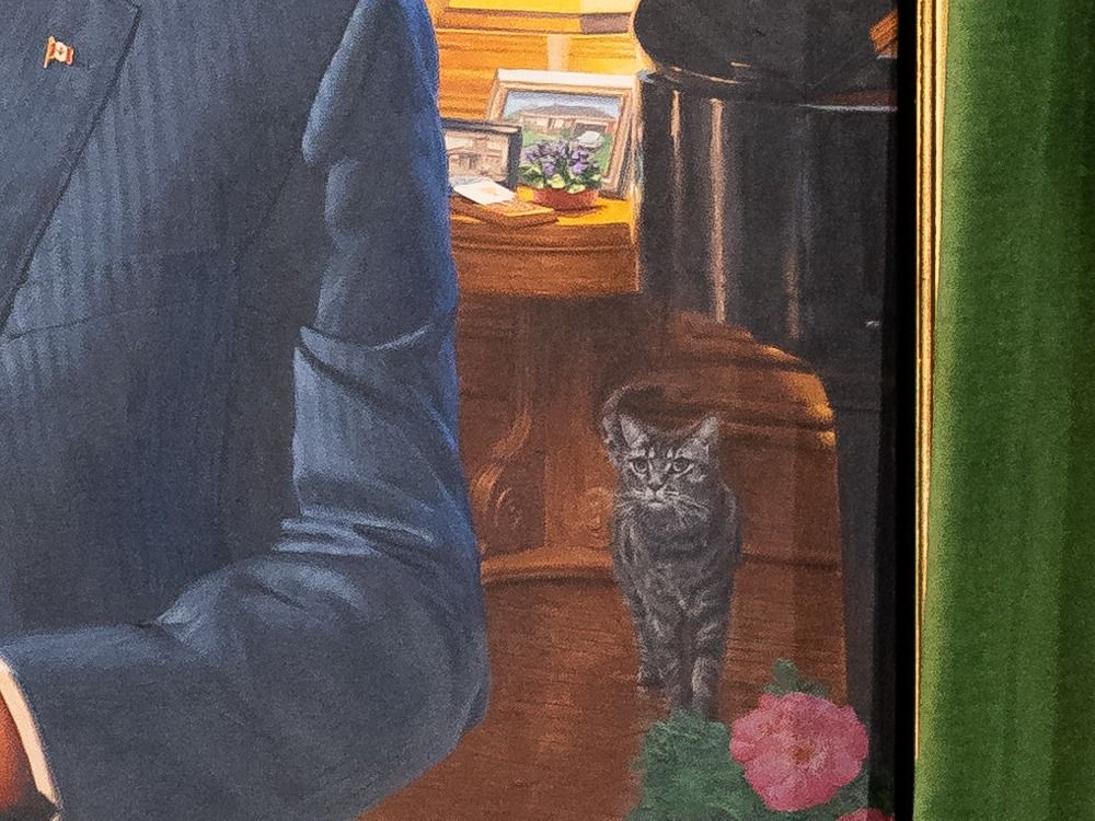  A detail of the portrait shows Stanley the cat, Harper’s Canada pin, a cribbage board and two old photos.