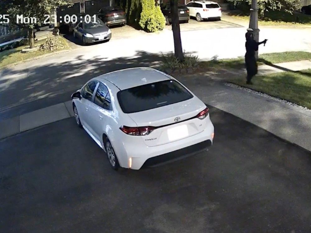  A suspect can be seen wearing all black while shooting a firearm in a residential area in the summer of 2025.