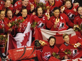 Members of the Canadian women's hockey team celebrate after winning gold at the 2006 Winter Olympic Games in Turin, Italy.