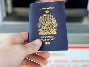 A hand holding a Canadian passport