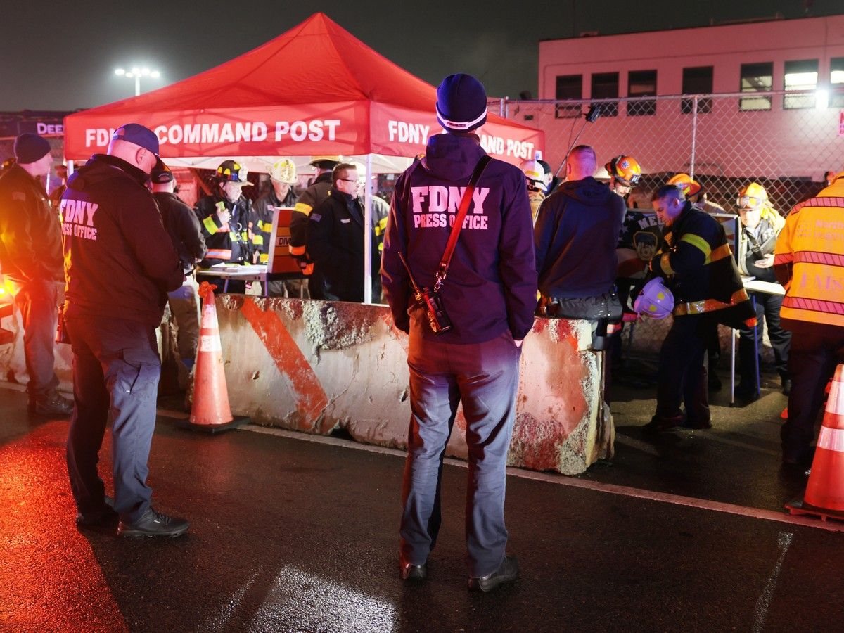 Emergency workers gather at the scene after an Air Canada Express plane collided with a fire truck on the tarmac at LaGuardia Airport on March 23, 2026.