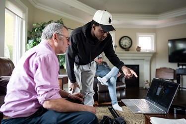 Maddox Bentley looks at photos with reporter Peter Kuitenbrouwer in Abbotsford, B.C., on Tuesday, Feb. 17, 2026.