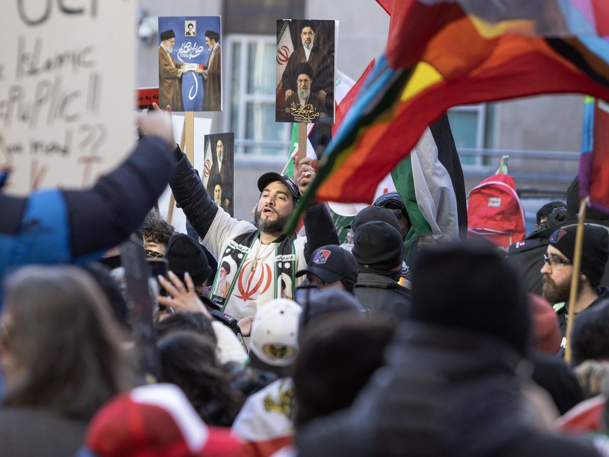 Pro-Iranian regime protester (centre) holds images of the Ayatollahs past and present, outside the U.S. Consulate in Toronto, Saturday, March 14, 2026. (Photo By Peter J Thompson/National Post) Pro-Iranian regime protester (centre) holds images of the Ayatollahs past and present, outside the U.S. Consulate in Toronto, Saturday, March 14, 2026. (Photo By Peter J Thompson/National Post)