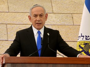 Israeli Prime Minister Benjamin Netanyahu speaks from behind a lectern.
