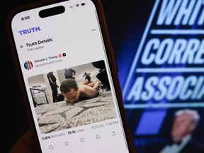 a phone with a Truth Social post by US President Donald Trump displaying an image of the alleged suspect in a shooting incident at the White House Correspondents' Dinner on the ground after being apprehended