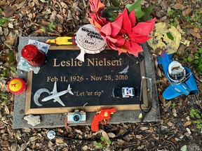 Grave marker covered with toys.