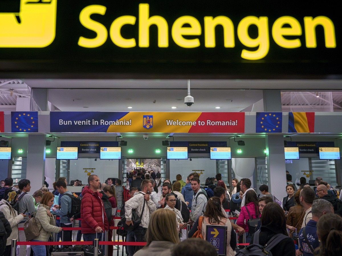  Passengers arriving at the Henri Coanda International Airport pass under a Schengen Information sign, in Otopeni, near Bucharest, Romania (AP Photo/Andreea Alexandru)