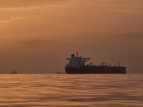 The sun rises behind tankers