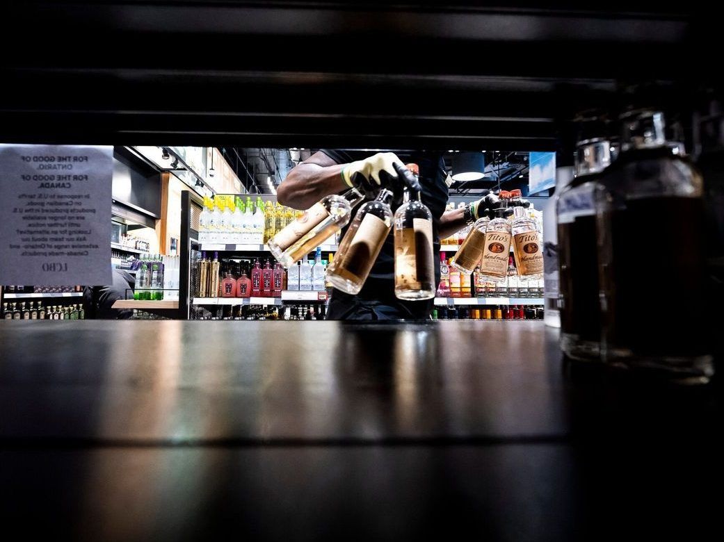  A worker removes bottles of American-made Tito’s vodka from a shelf at the Liquor Control Board of Ontario (LCBO) Queen’s Quay store in Toronto.