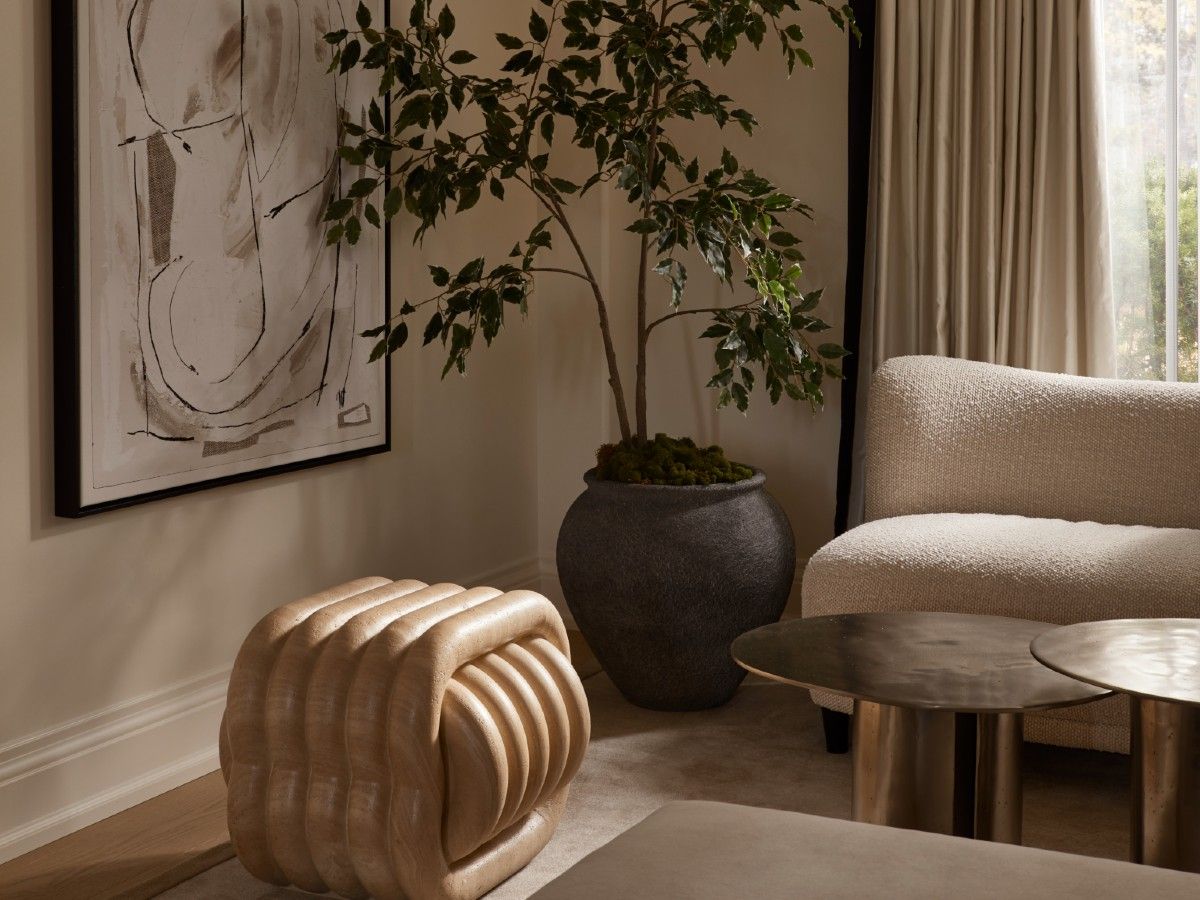 A ficus in an earthy vase and a quirky stone stool from Bettencourt Manor bring personality into the formal living room.