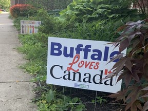 Buffalo loves Canada sign in bushes along a sidewalk