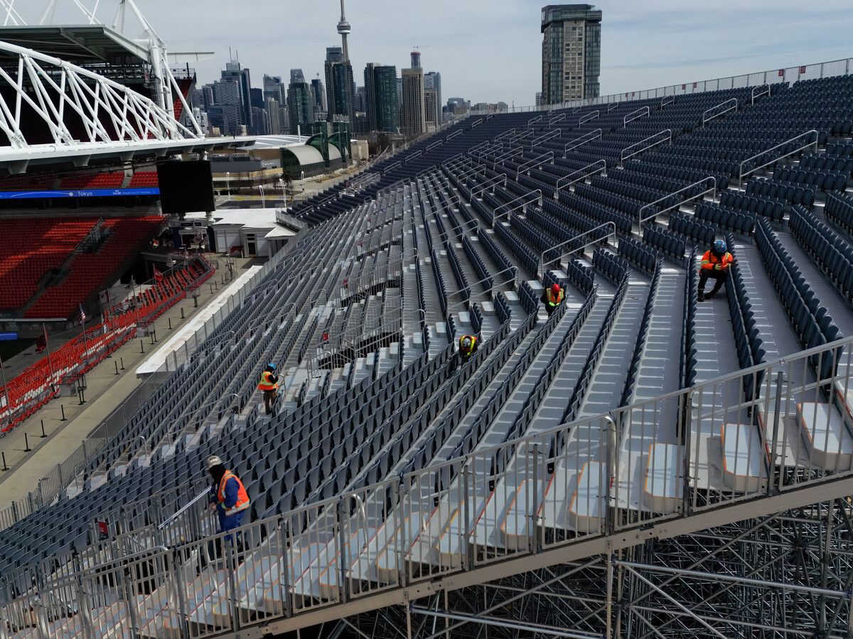  Workers are seen assembling temporary bleacher seating to add extra capacity near the regular stands at BMO Field in Toronto on March 24, 2026.