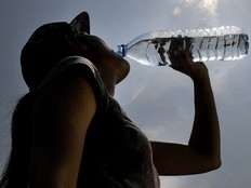A woman drinks water from a plastic bottle