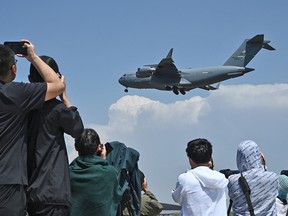 People watch a plane land.