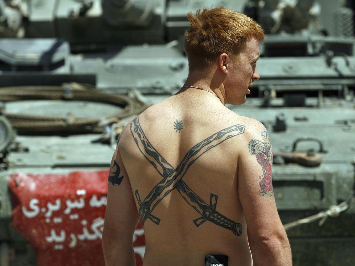 A soldier gets sun on his tattoos