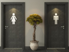 Two black restroom doors with white female and male icons on the front