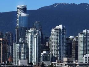 The Vancouver skyline with a mountain and blue sky in the background.