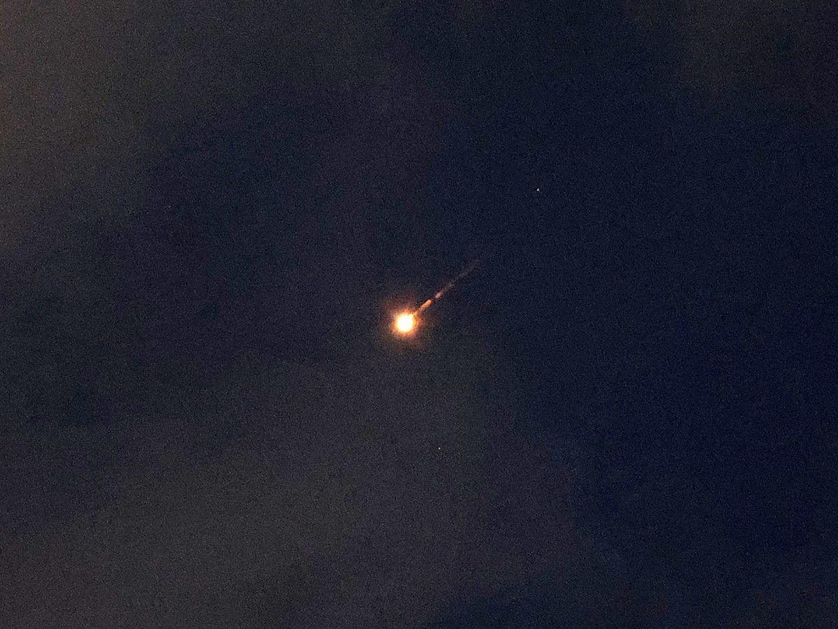 A rocket trail is seen in the night sky