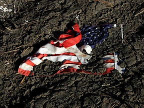 A tattered American flag lies in mud in the backyard of a destroyed house December 26, 2005 in St. Bernard Parish, Meraux, Louisiana.